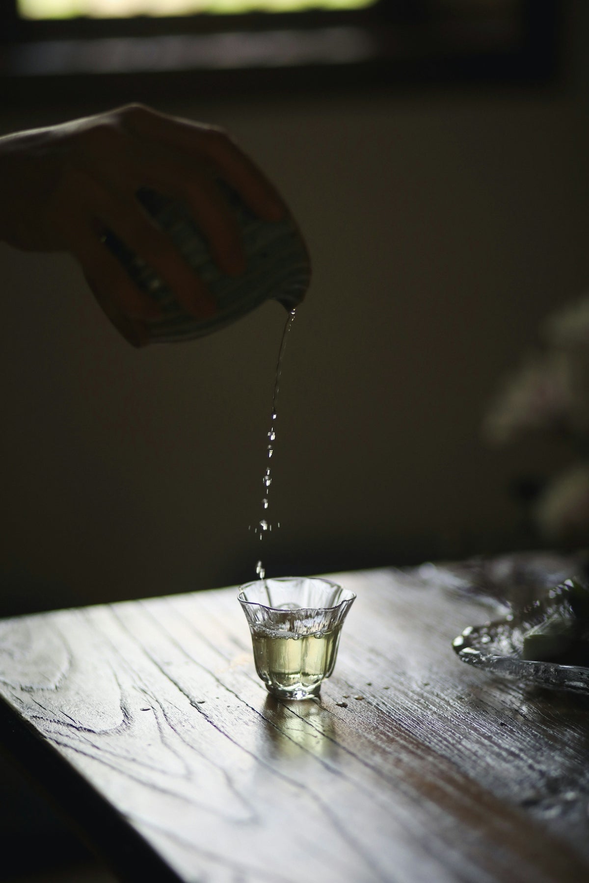 a glass of water being poured into a glass with a straw