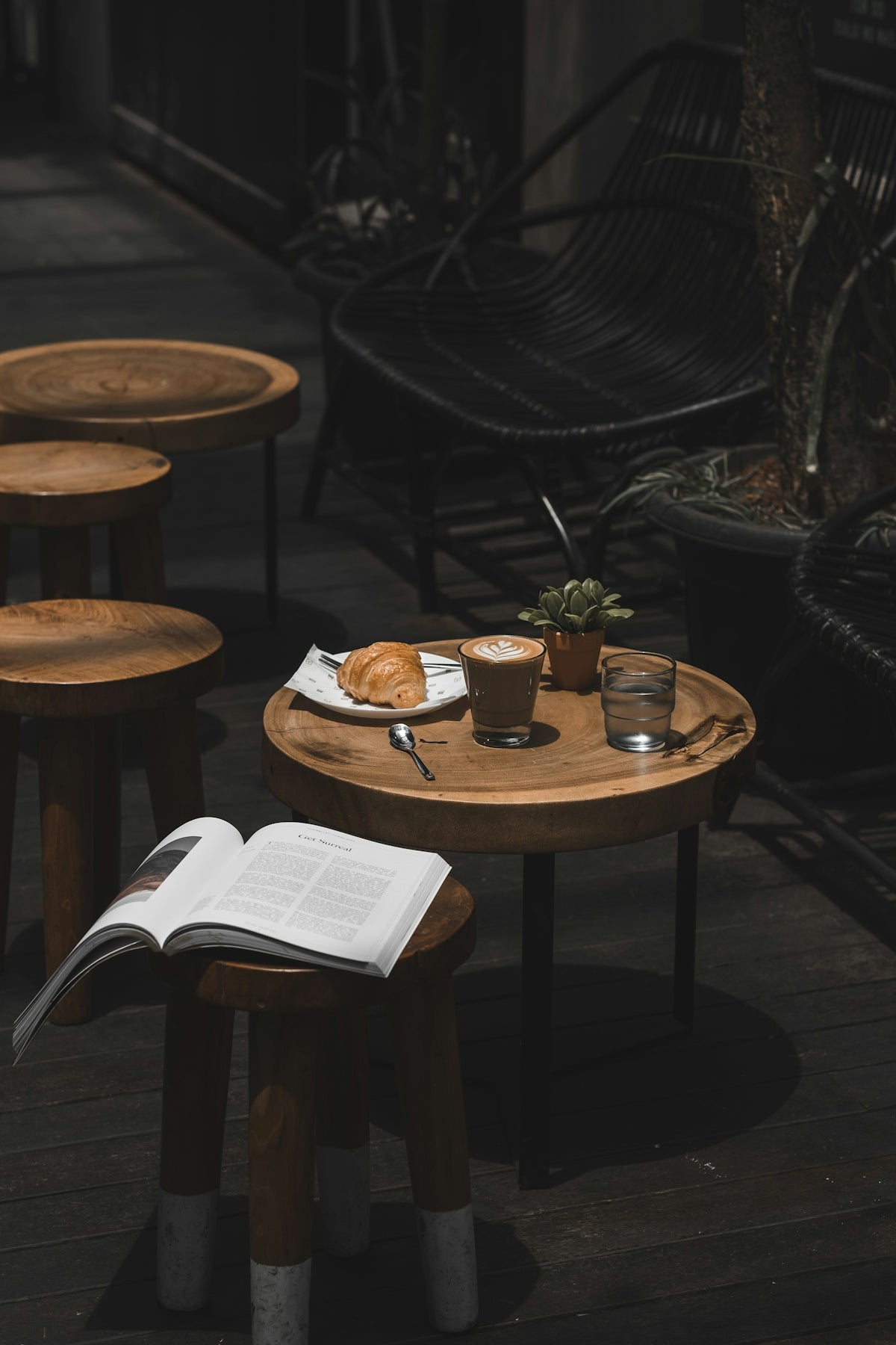 latte croissant and book on cafe table