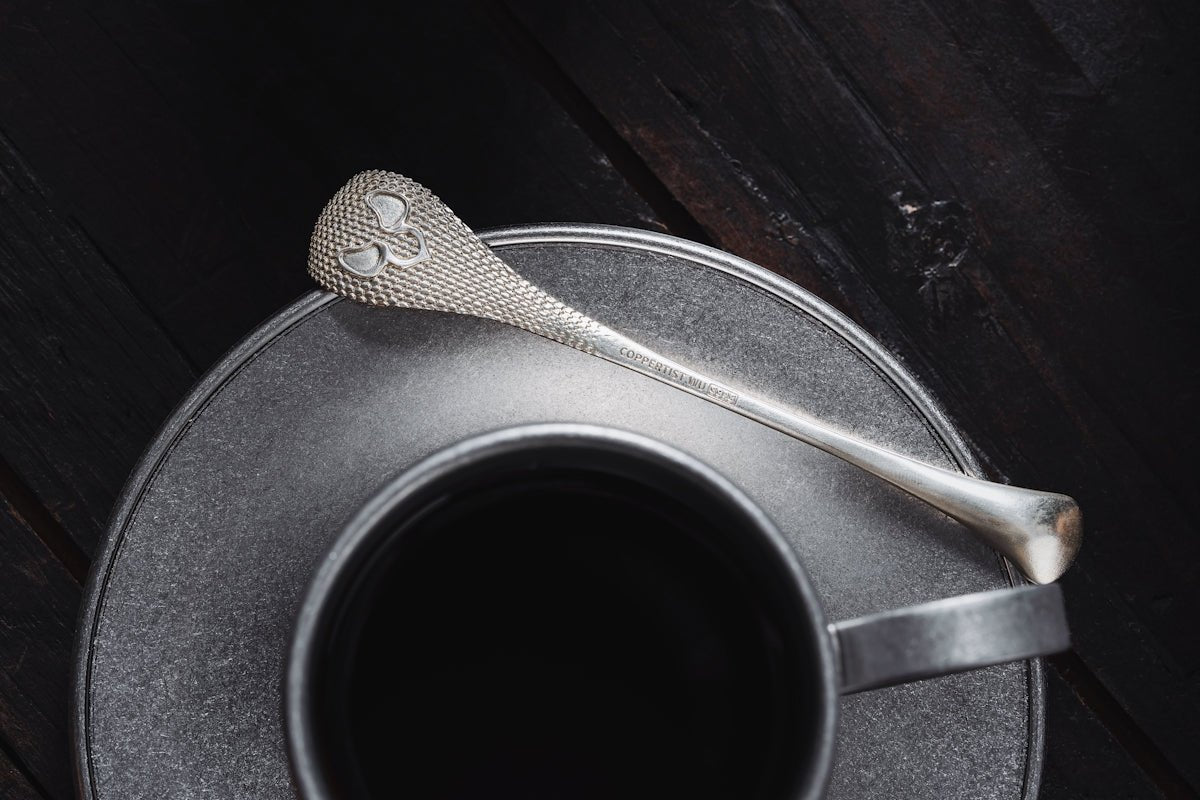a cup of coffee with a spoon on a saucer
