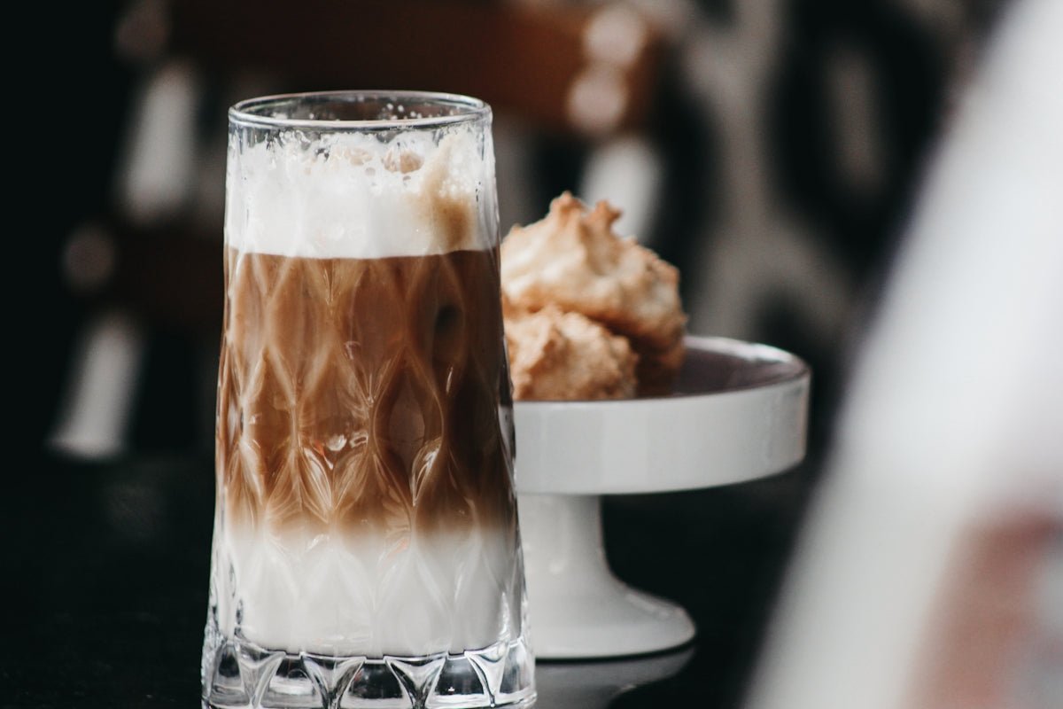a close up of a cup of coffee and a plate of food