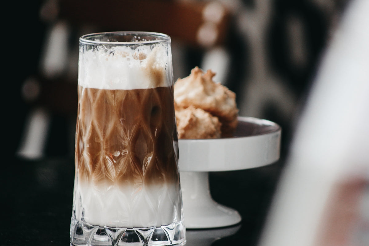 a close up of a cup of coffee and a plate of food