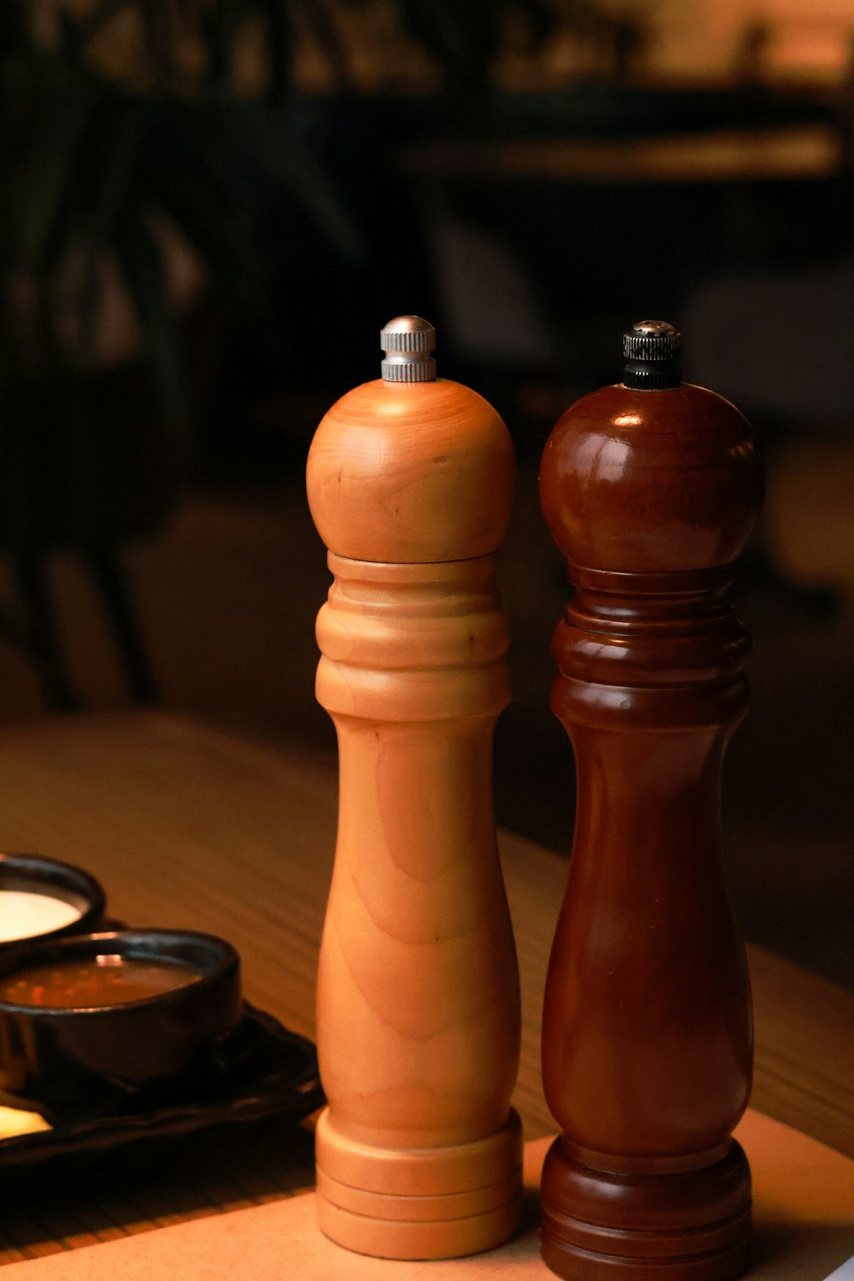 a wooden pepper mill and pepper grinder on a table