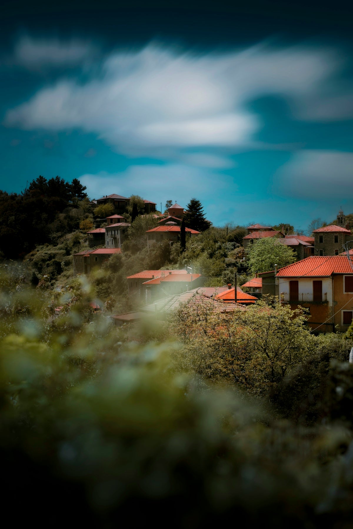 a view of some houses on a hill under a cloudy sky