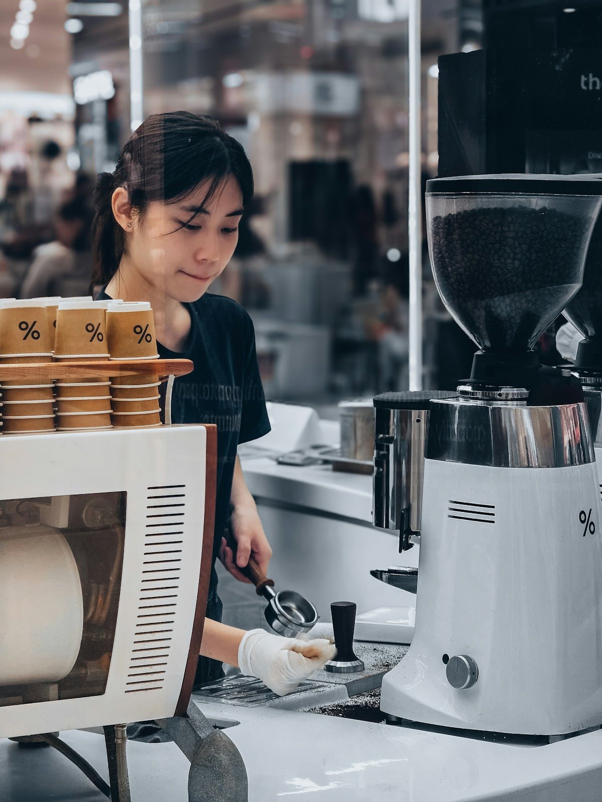 Barista preparing coffee with grinder and cups