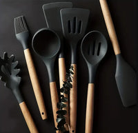 Thumbnail for Set of kitchen utensils with black silicone heads and wooden handles on a dark background