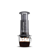 Thumbnail for Aeropress coffee maker dispensing coffee into a glass mug on a white background