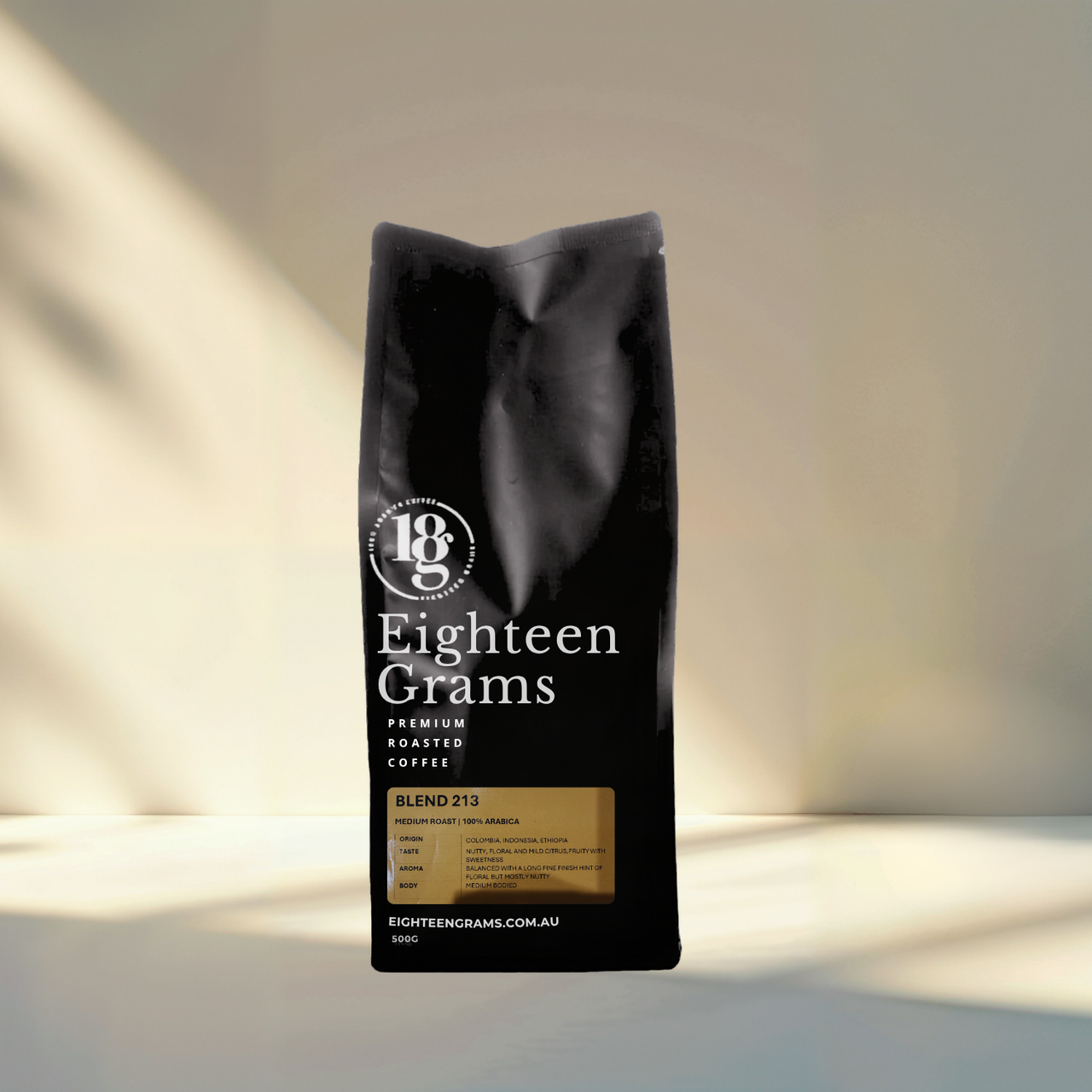 Black coffee bag with 'Eighteen Grams' branding on a neutral background