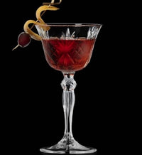 Thumbnail for Red cocktail in a decorative glass with garnishes on a black background
