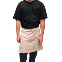 Thumbnail for Person wearing a black t-shirt with 'essentials' text and a beige apron on a white background