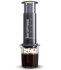 Thumbnail for Aeropress coffee maker with coffee dripping into a glass container on a white background