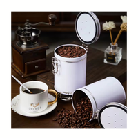 Thumbnail for White canister with coffee beans next to a cup of coffee on a wooden table.