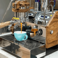 Thumbnail for Espresso machine with wooden accents pouring coffee into a blue mug.