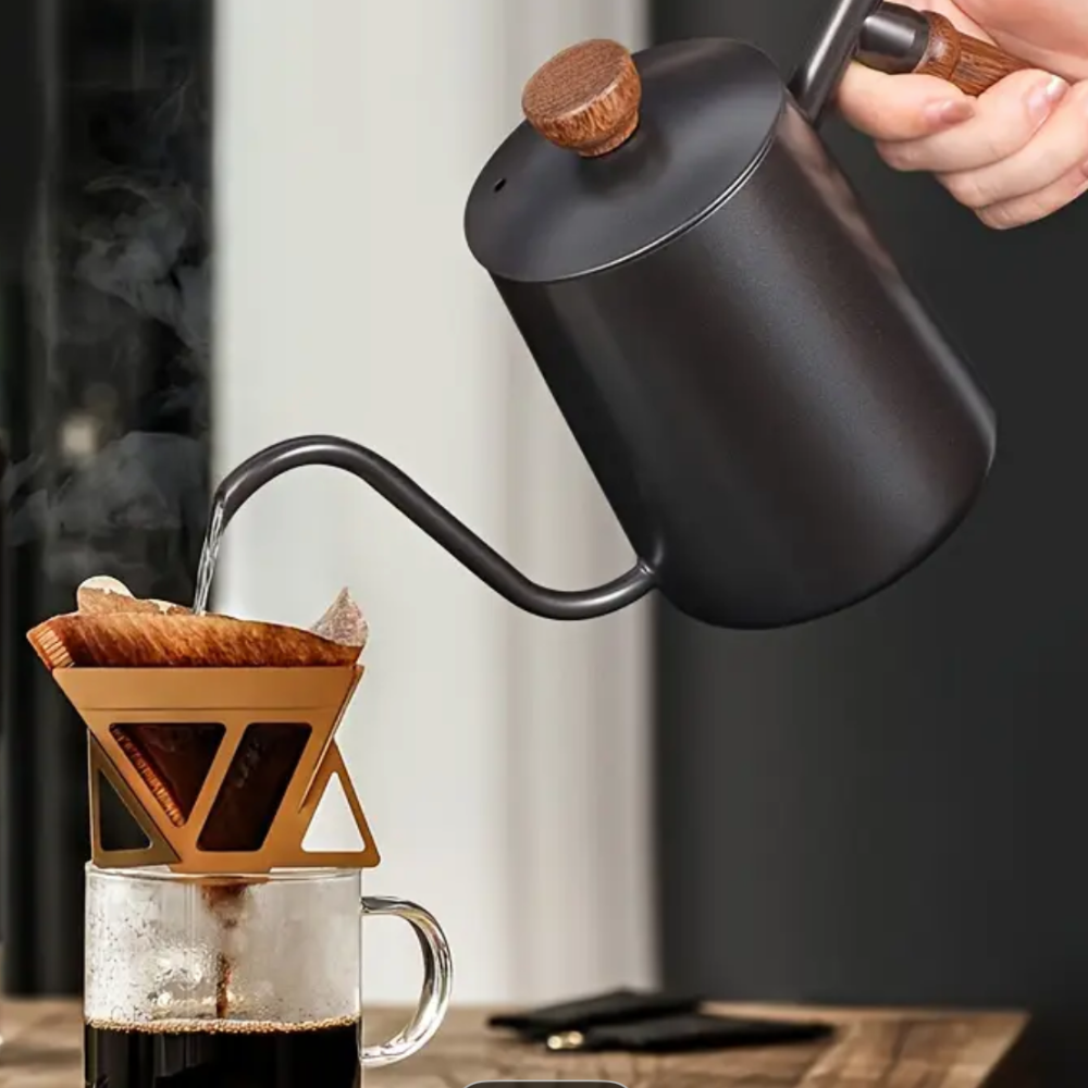 Black gooseneck kettle pouring coffee into a glass mug with a wooden handle.