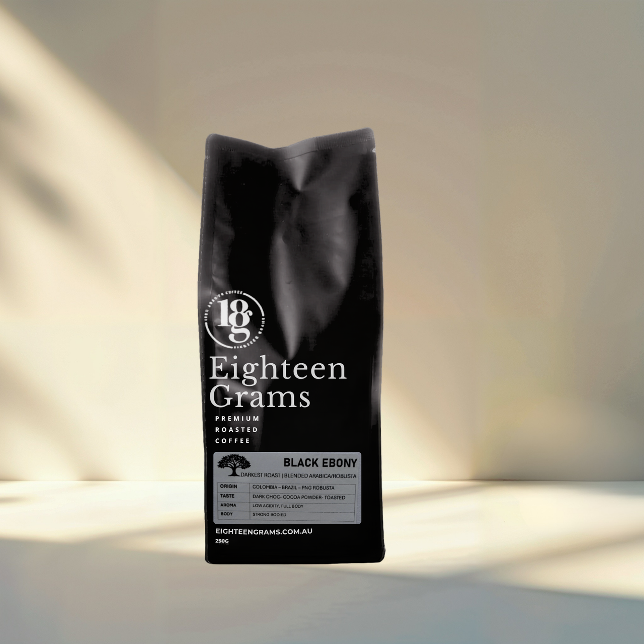 Black coffee bag labeled 'Eighteen Grams' on a neutral background. A bold dark roast coffee blend featuring Colombian, Brazilian, Papua New Guinean and Robusta beans, ideal for espresso, stovetop and milk-based coffees.