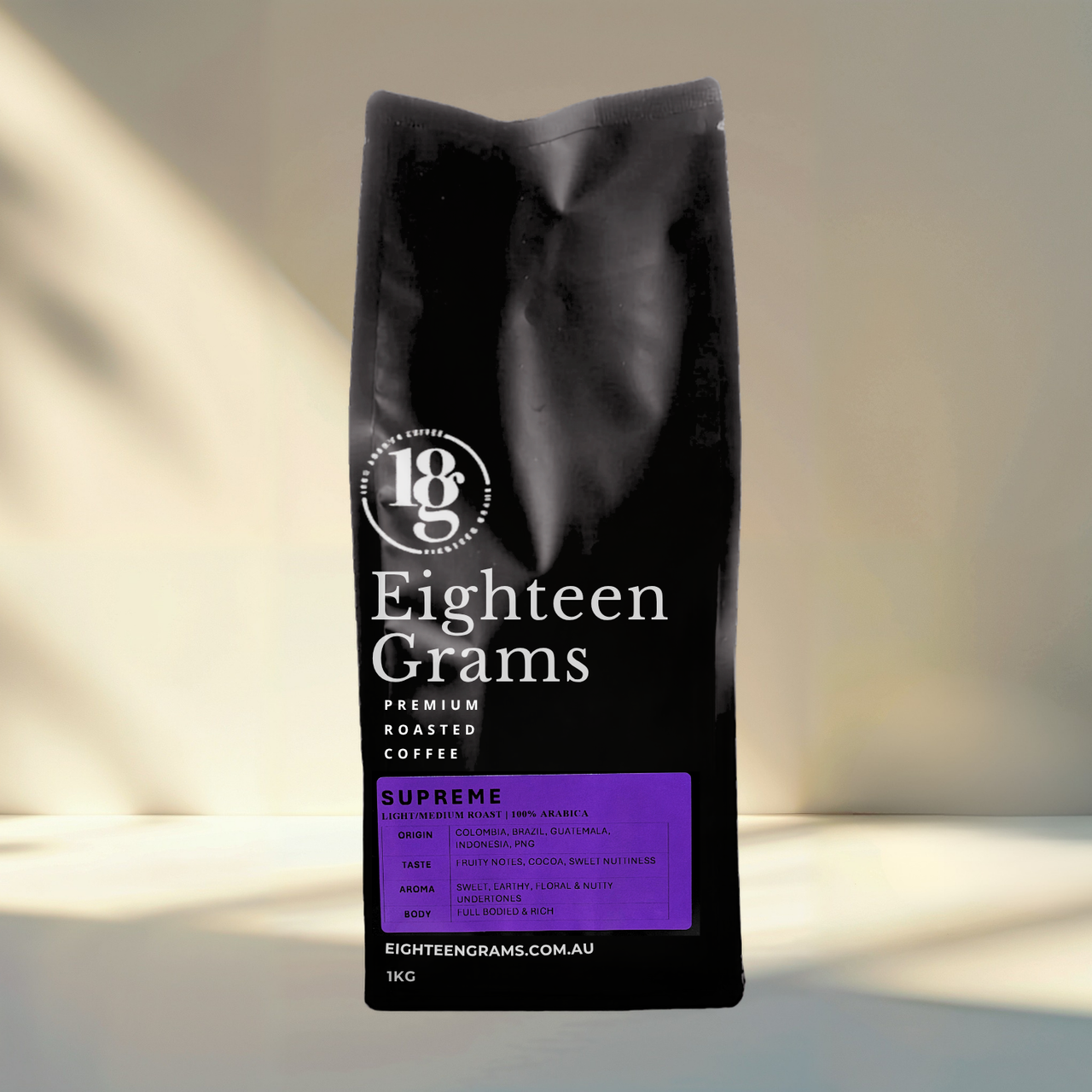Black coffee bag labeled 'Eighteen Grams' on a light background.blend-supreme-light-medium-roast-coffee-beans