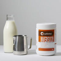 Thumbnail for Cafetto Inverso Milk Jug Cleaner next to a bottle of milk and a metal pitcher on a light gray background