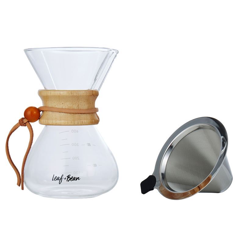 Clear glass coffee maker with wooden collar and brown leather tie, accompanied by a metal filter on a white background.