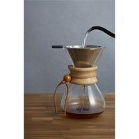 Thumbnail for Coffee brewing process using a wooden coffee dripper on a wooden surface with a gray background.