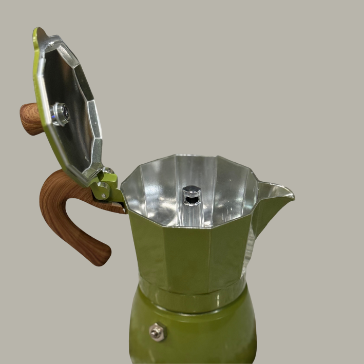 Green and silver Moka pot with wooden handle on a gray background