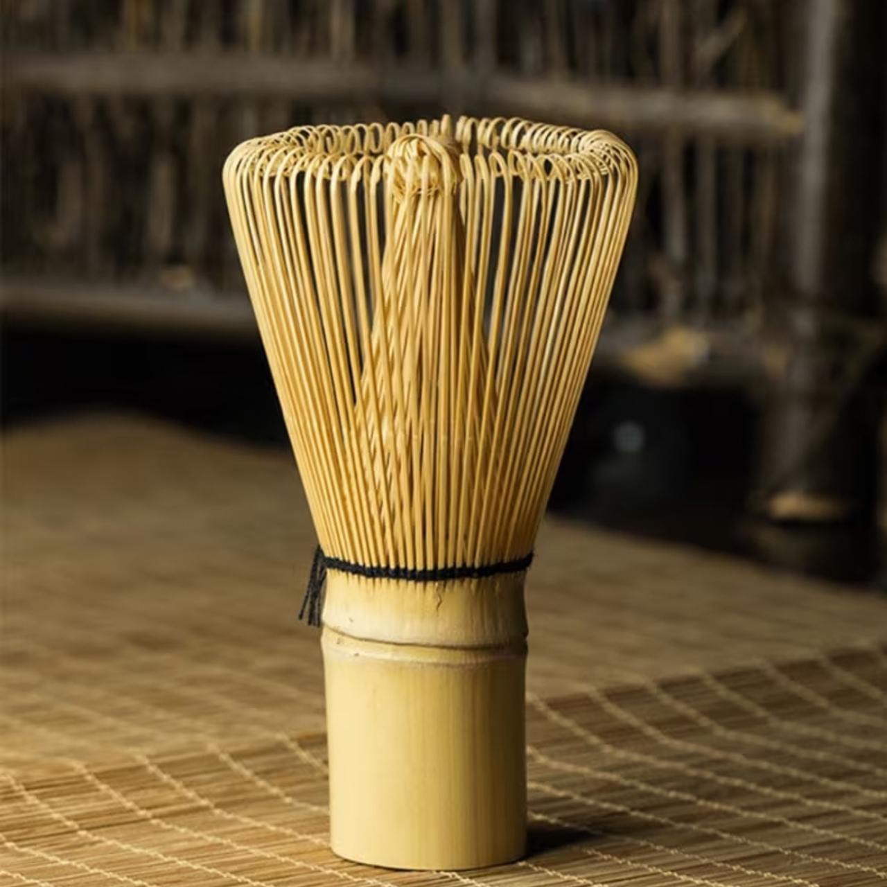 Bamboo whisk used for making matcha tea on a woven mat