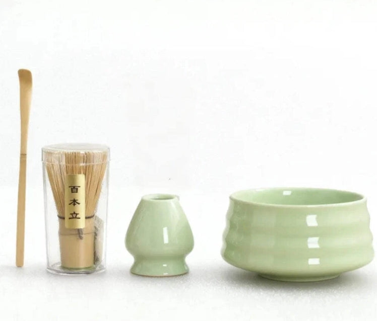 Tea-making set with green ceramic bowls and a glass container on a white background