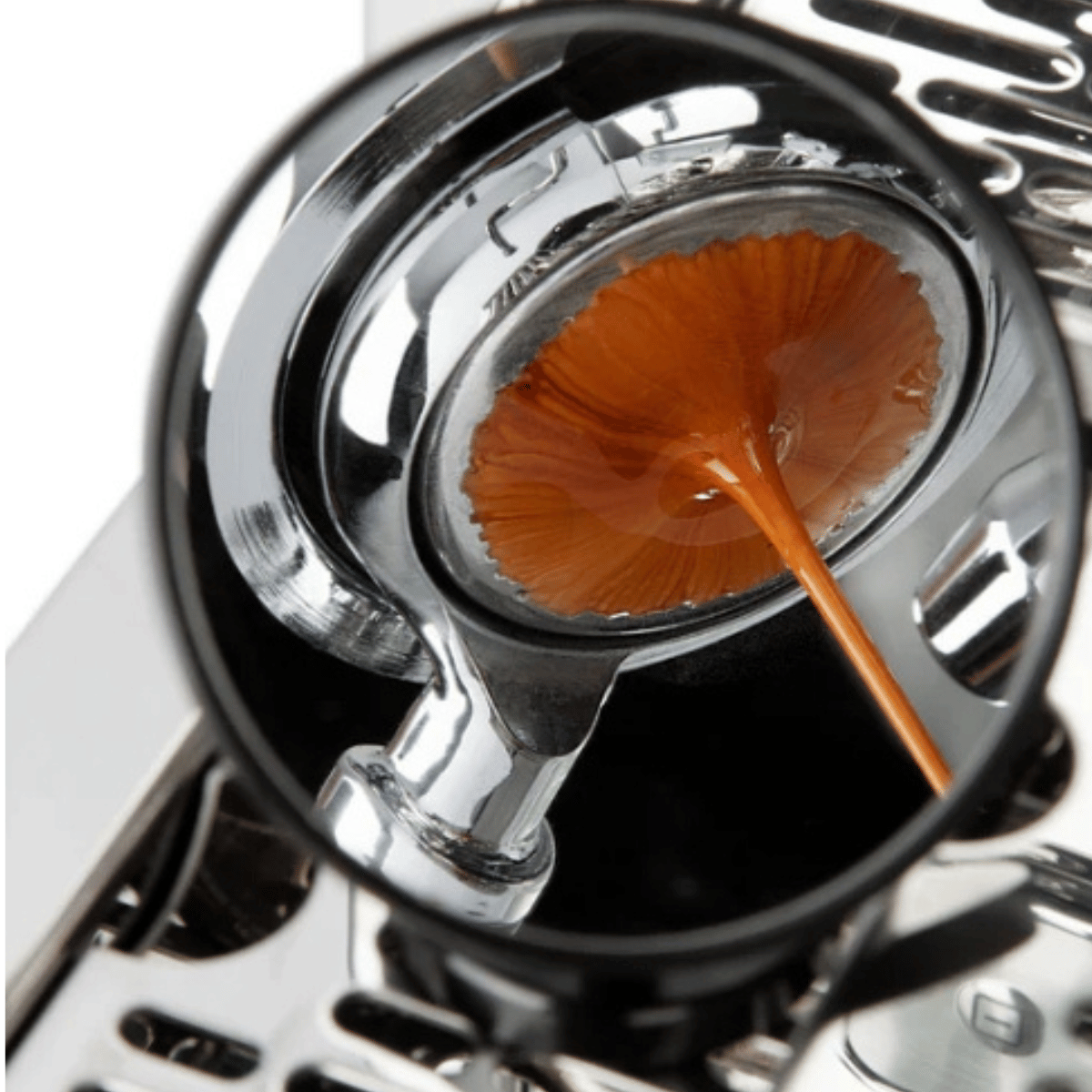 Close-up of a coffee filter with a spoon in a coffee machine.