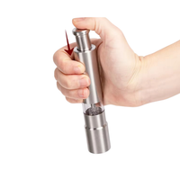 Thumbnail for Hand holding a silver pepper grinder on a white background