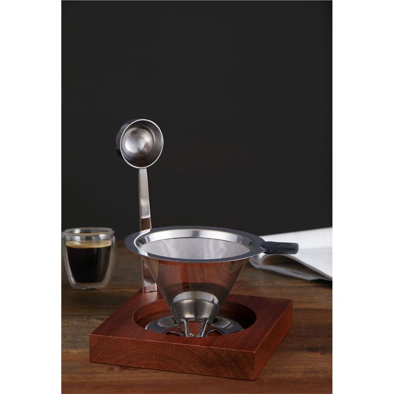 Coffee brewing device with a glass of coffee on a wooden surface