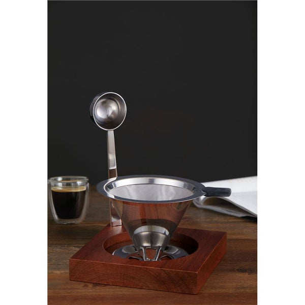 Coffee brewing device with a glass of coffee on a wooden surface