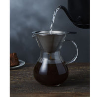 Thumbnail for Pouring liquid into a glass carafe with a metal filter on a wooden surface.