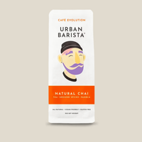 Thumbnail for A package of Urban Barista Natural Chai tea, featuring a white bag with a stylized illustration of a man's face and a prominent orange band at the bottom.